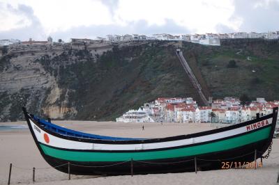 La plage de Nazaré et un bateau de pêche survivant